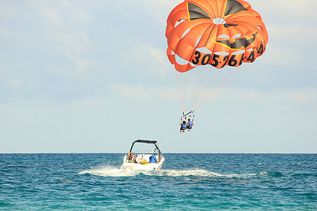 two person riding on parachute in flight above body of water thumbnail