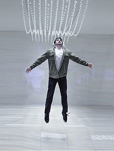 man jumping inside well lit room thumbnail