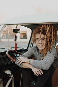 man wearing gray shirt sitting inside car thumbnail