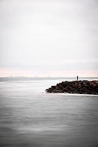 landscape photography of person standing on rock thumbnail