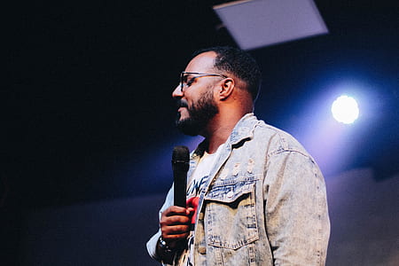 man standing while holding microphone thumbnail
