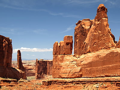 brown rock monolith under blue cloudy sky thumbnail