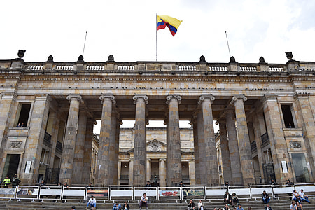 low-angle photo of Spain flag on brown concrete museum under white sky thumbnail