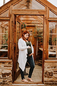 pregnant woman at the green house doorway thumbnail