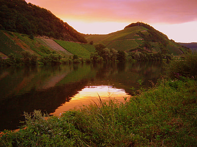sunset over mountains and body of water thumbnail