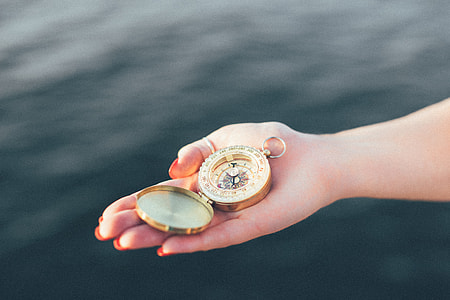 person holding round gold pocket watch on focus photo thumbnail