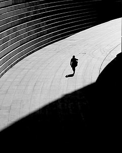 silhouette of person walking on concrete road thumbnail