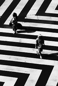 grayscale photography of man and woman walking on road thumbnail