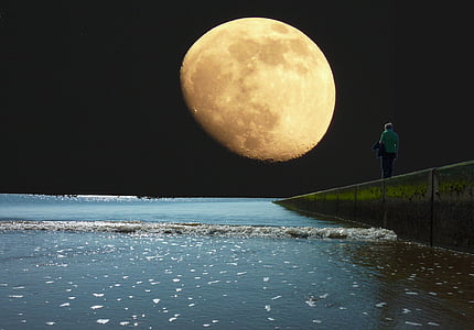 person near body of water during full moon thumbnail