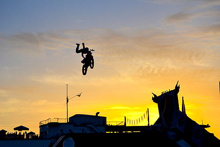 silhouette photography of man doing tricks on dirt bike thumbnail