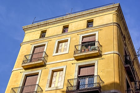 low angle photography of brown concrete building under blue sky thumbnail