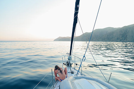 woman sitting on boat across mountain thumbnail