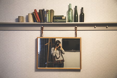 brown framed mirror hanged on beige wall thumbnail