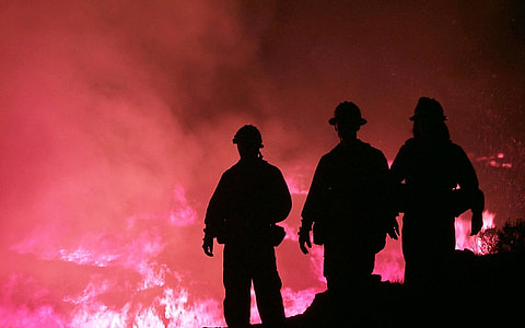 silhouette photo foot of three firemen on hill thumbnail