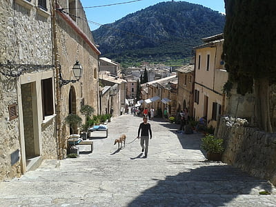 man and his dog walking on narrow street thumbnail