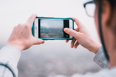person taking photo of city thumbnail