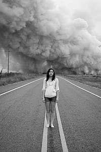 grayscale photography of woman standing on road thumbnail