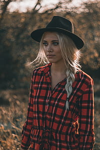 woman wearing red and black plaid dress shirt with black hat thumbnail