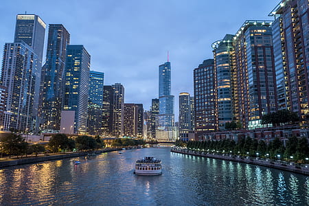 yacht on body of water between lighted building at night thumbnail