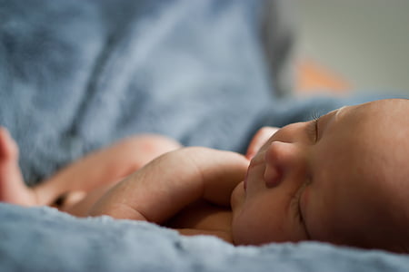 baby sleeping on gray textile thumbnail