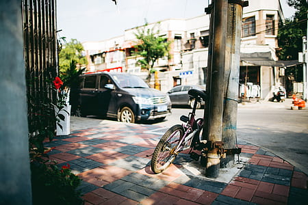 bike parked beside the post near car thumbnail