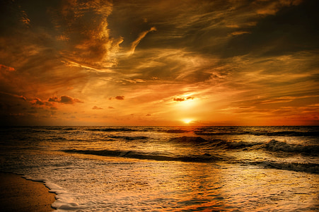 sea against yellow sunlight under grey clouds thumbnail