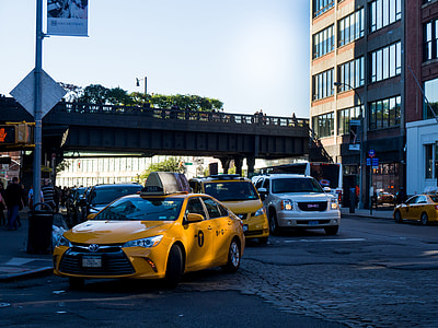 yellow Toyota Camry taxi near post light in front of building thumbnail