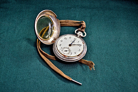 round gray pocket watch with strap on gray textile thumbnail
