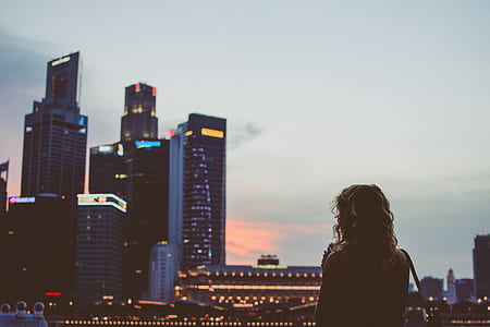 woman looking at the distance towards high-rise buildings thumbnail