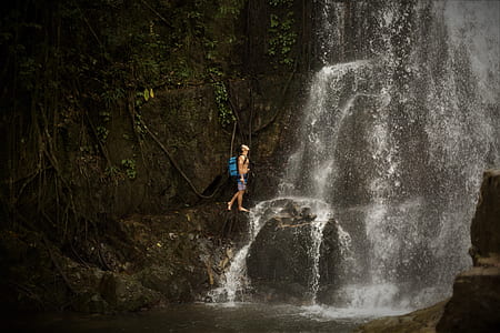 man walking under waterfal thumbnail