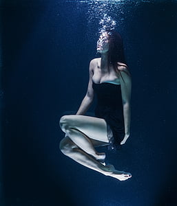 woman in black tube dress floating underwater thumbnail