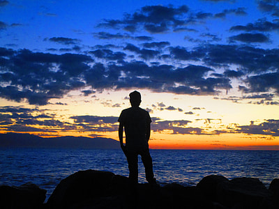 silhouette of man standing on seashore thumbnail