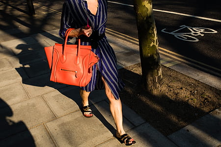 woman carrying brown bag under sunny sky thumbnail