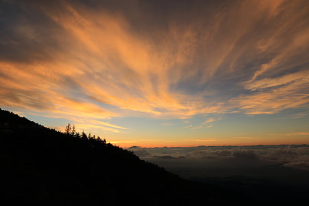 silhouette of mountain under orange and blue sky at sunset thumbnail