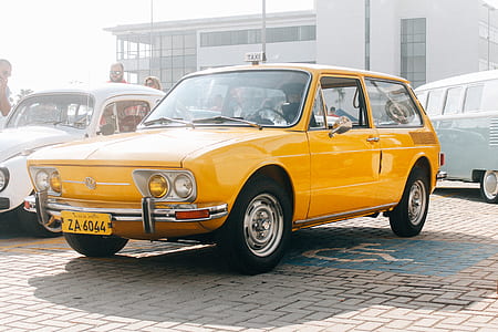 yellow 3-door hatchback on concrete pavement thumbnail