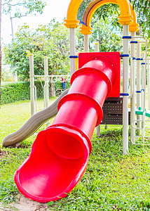 red and white slide playset on green grass thumbnail