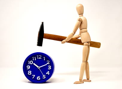 figure holding hammer beside blue desk clock thumbnail