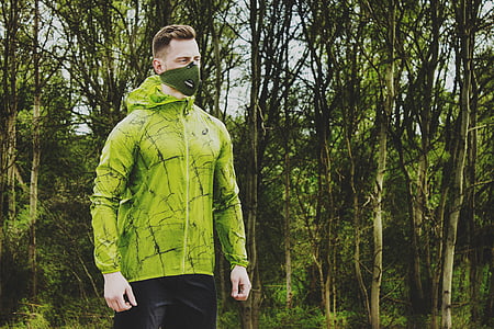 man wearing green hoodie beside trees thumbnail