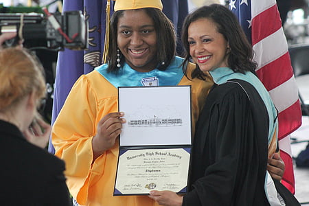 woman standing next to another woman holding diploma thumbnail