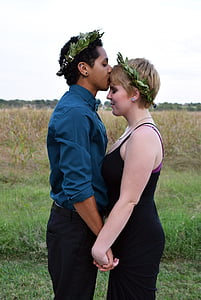 man kissing girl on forehead while holding hands during daytime thumbnail