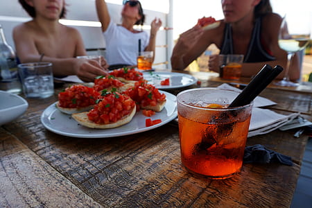bread with salsa on plate beside glass of juice with straw thumbnail