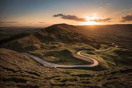 landscape photography of road between hills during golden hour thumbnail