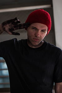 man wearing red knit cap and black crew-neck shirt thumbnail