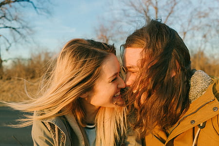 smiling man and woman near trees during daytime thumbnail