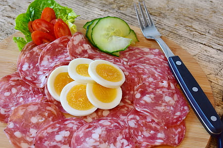 sliced sausages and eggs on wooden plate thumbnail