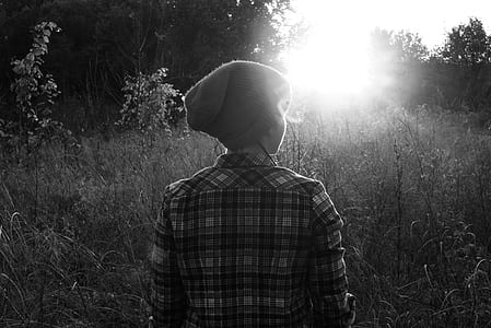 grayscale photography of person standing plants thumbnail