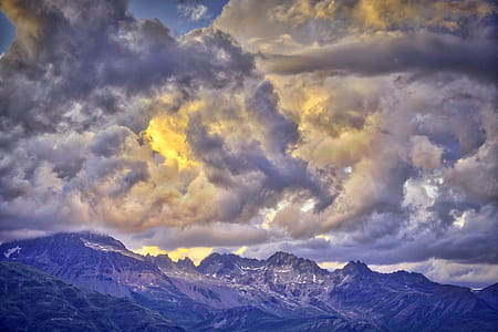 mountains under nimbus cloud during daytime thumbnail