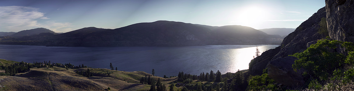 calm body of water surrounded with mountains at daytime thumbnail