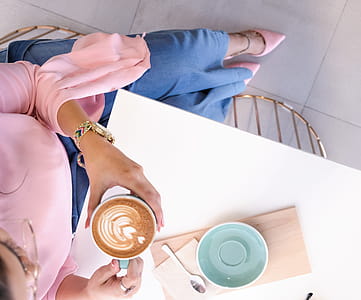 Woman Holding Mug With Coffee Sitting at Desk thumbnail