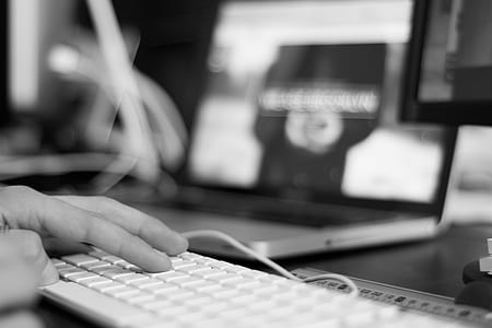 grayscale macro photography of person using white keyboard thumbnail
